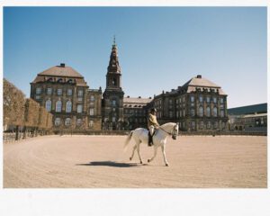 a person riding a horse in a dirt arena