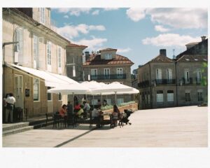 people sitting at tables in a courtyard