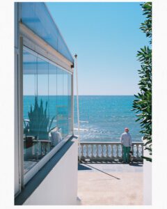 a man standing on a balcony overlooking the ocean