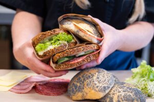 a person holding sandwiches in their hands