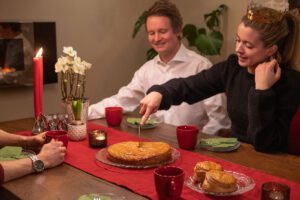 a group of people sitting around a table with a cake
