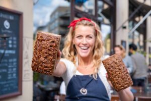 a woman holding two loafs of bread