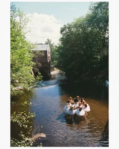 a group of people in tutu skirts in a river